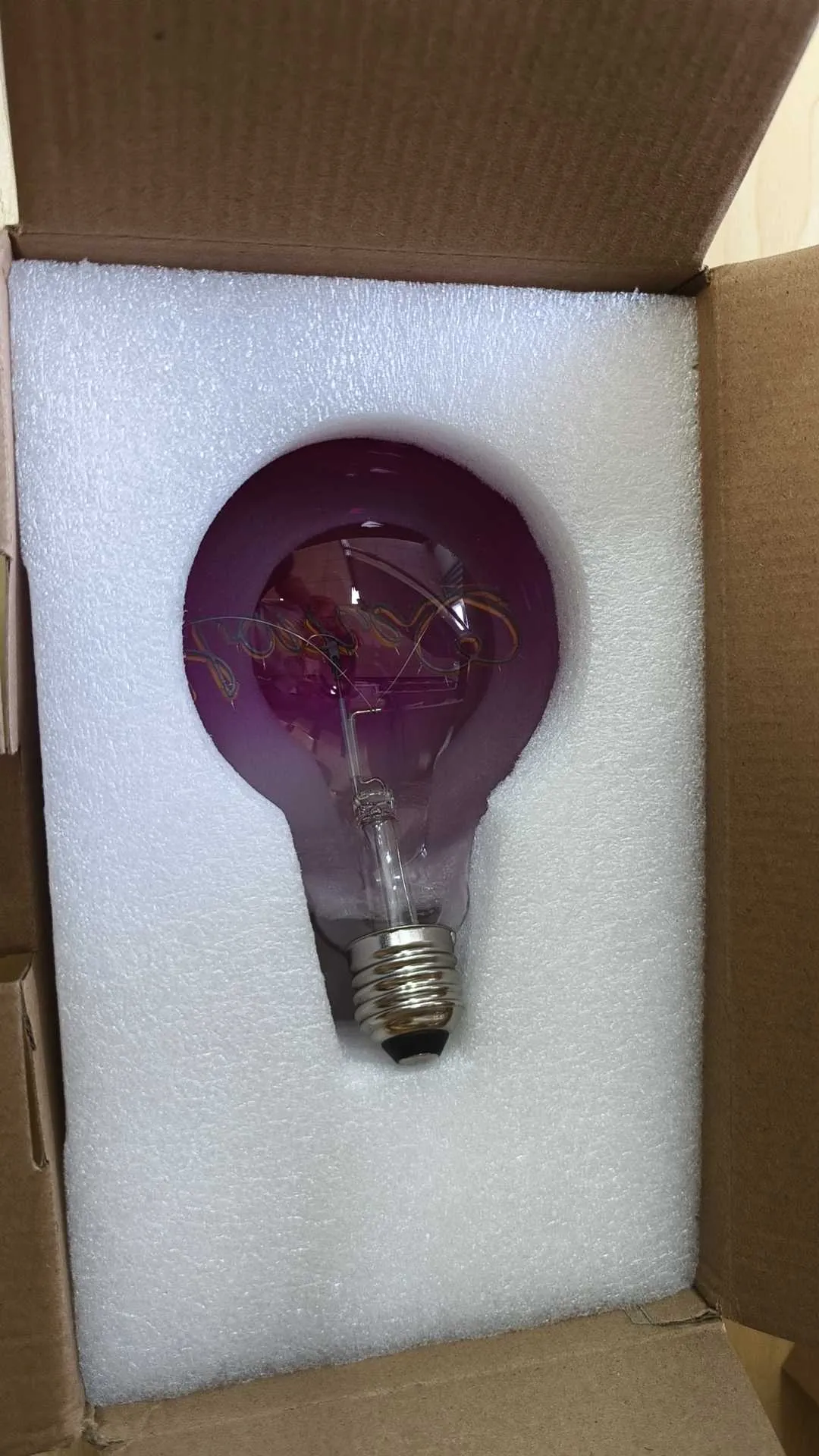 Decorative glass bulb secured in custom-cut protective foam inside a carton